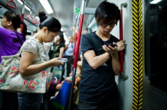 People using smartphones in subway train